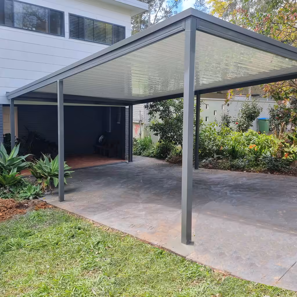 Spacious DIY freestanding flat roof carport next to a house.