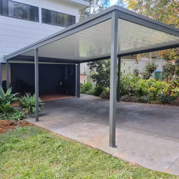 Spacious DIY freestanding flat roof carport next to a house.