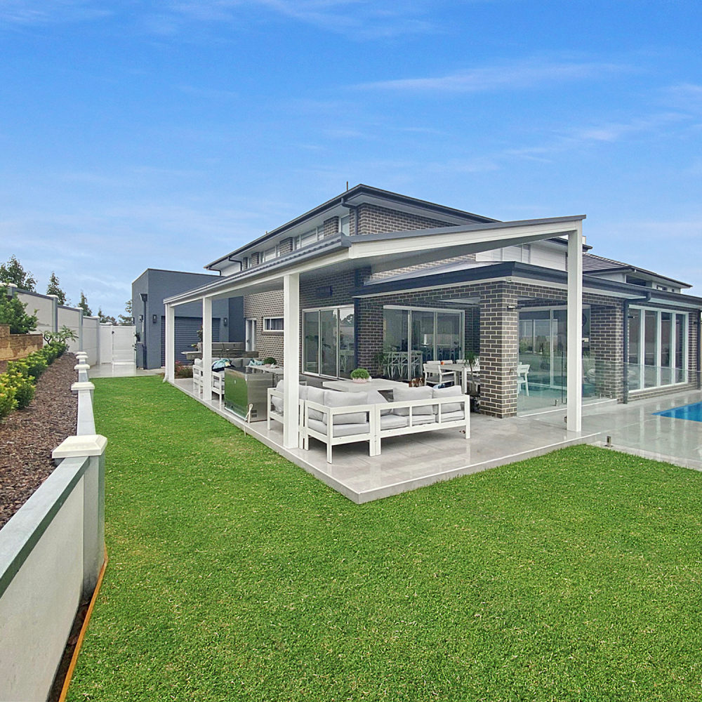 Modern home with DIY attached flyover flat roof patio/pergola and green lawn.