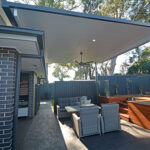 DIY attached flyover flat roof patio/pergola with outdoor seating.