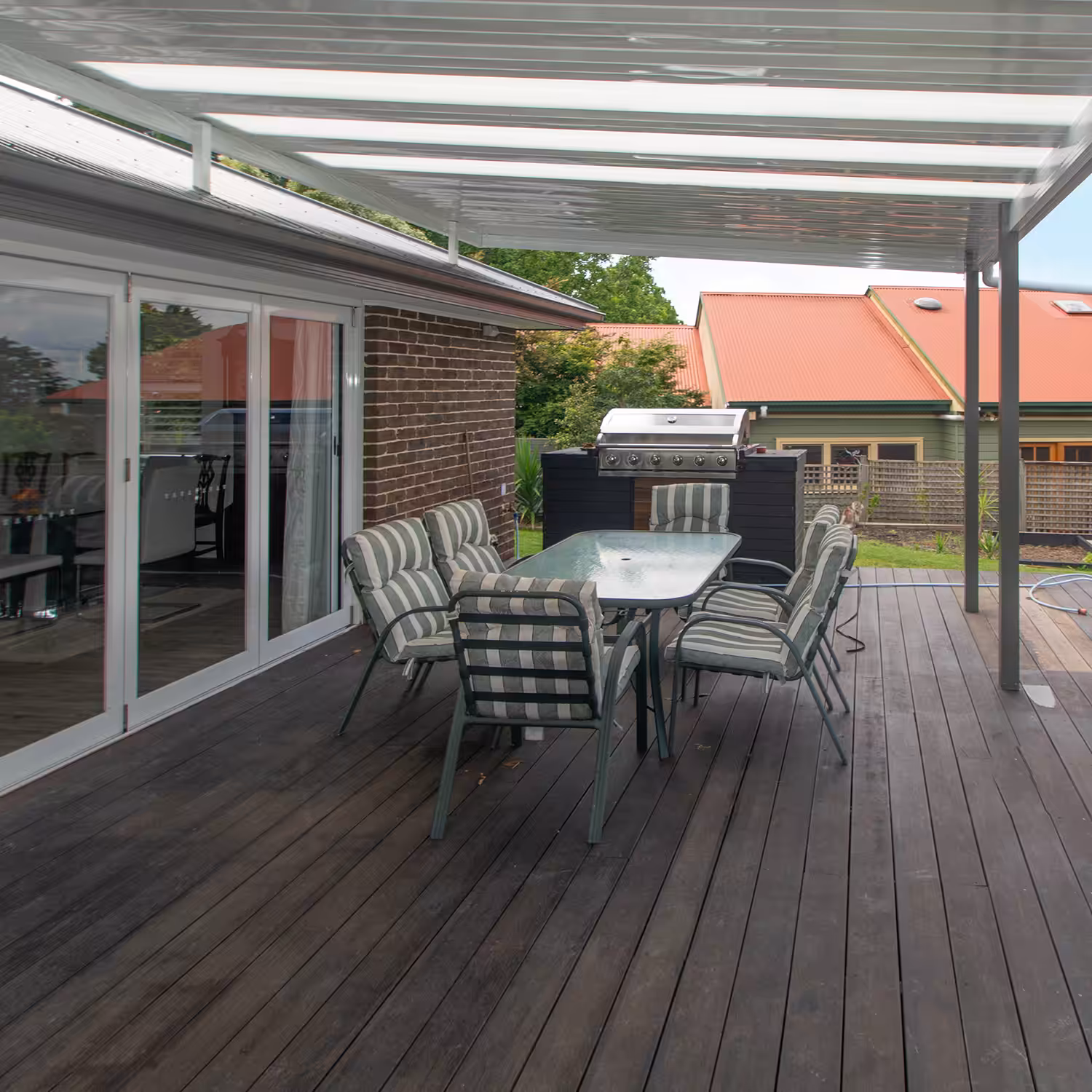 DIY attached flyover flat roof patio/pergola with barbecue and seating.