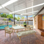 Stylish outdoor DIY attached flyover flat roof patio/pergola with dining table and pool.