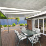 Outdoor DIY attached flyover flat roof patio/pergola with dining table and chairs.