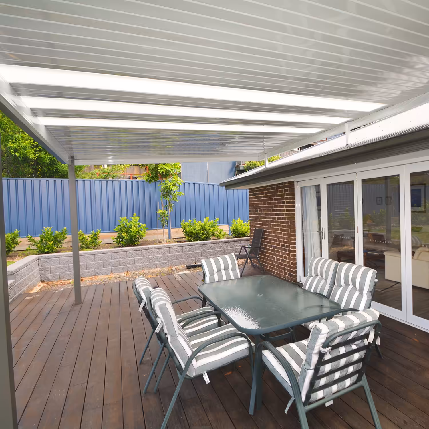 Outdoor DIY attached flyover flat roof patio/pergola with dining table and chairs.
