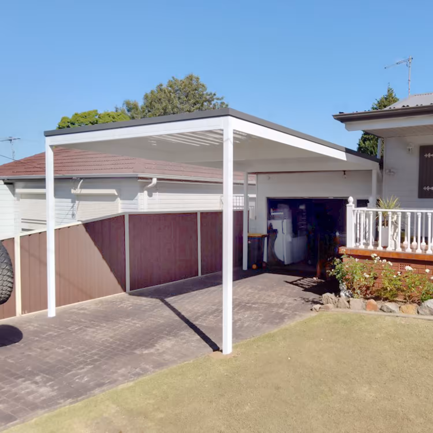 DIY attached flyover flat roof patio/pergola providing shade in residential backyard.