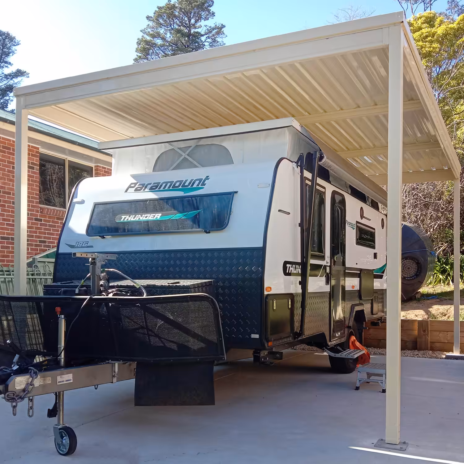 Caravan parked under a diy freestanding flat roof carport