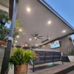 DIY attached flat roof pergola/patio area with plants and TV