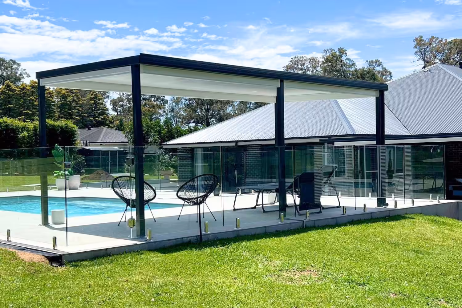 Modern patio and pool area with glass fencing