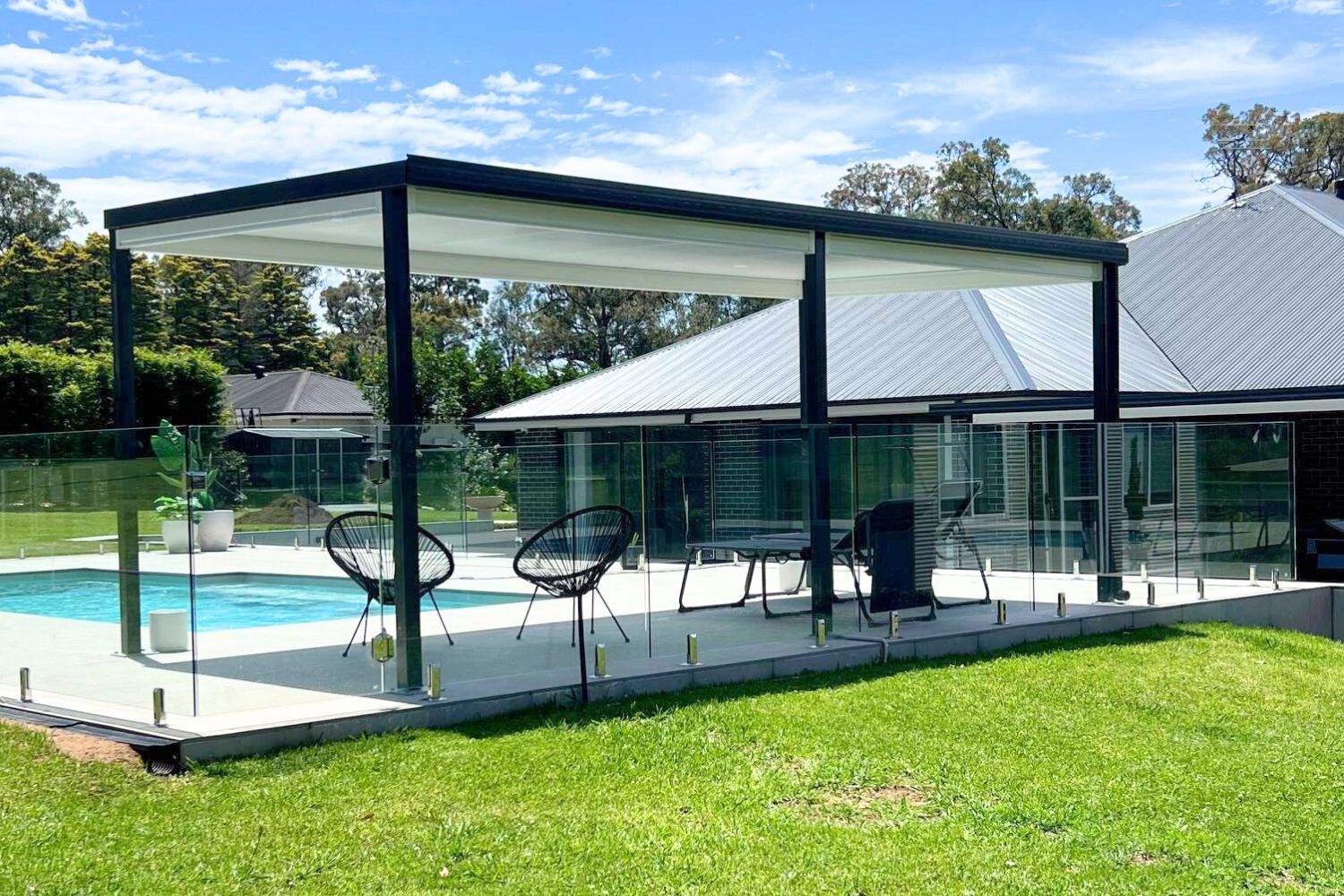Modern patio and pool area with glass fencing